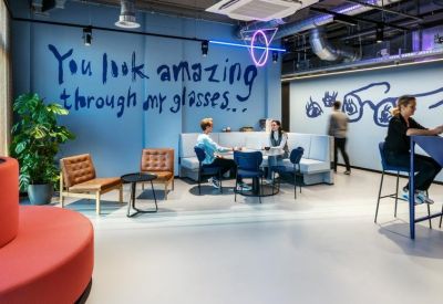 Modern lounge area with blue wall text reading You look amazing through my glasses.