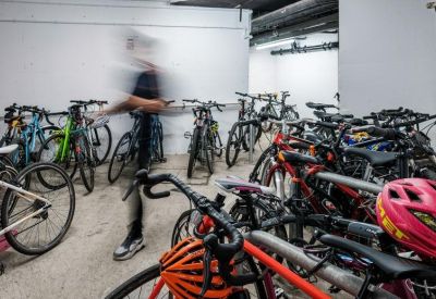 Indoor bicycle storage room with multiple bike racks and a person in motion.