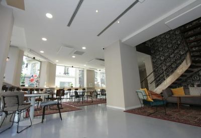 Lobby area featuring mixed seating, a spiral staircase, and patterned accent walls.