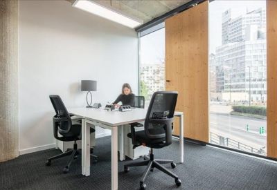 Sun-drenched lounge area with a white sofa, purple rug, and large windows.