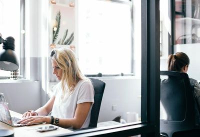 Private office workspace with a white desk and large window for natural light.