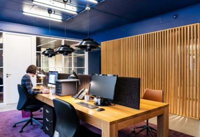 Professional workspace with wooden desks and a vertical slat room divider.