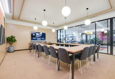 Large meeting room featuring a U-shaped wooden table and modern spherical pendant lighting.