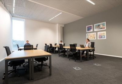 Spacious meeting room with a large rectangular table and black ceiling tiles.