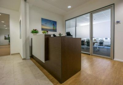 Modern wood-paneled reception desk with glass partitions.