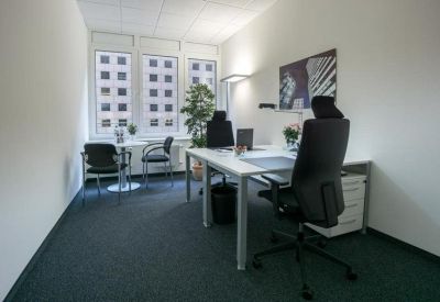 Spacious two-person office with grey carpet and large windows.