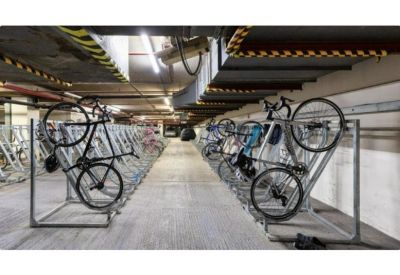 Secure indoor bicycle storage room with multi-level metal racks.