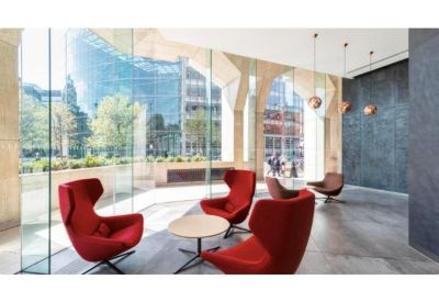 Modern lounge area featuring bright red armchairs and expansive city views.