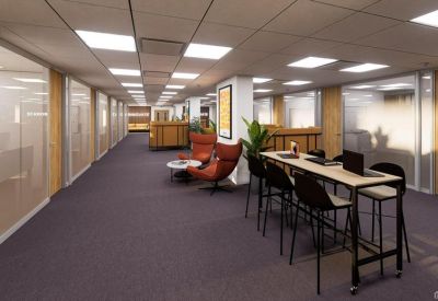 Wide office hallway with high tables and comfortable breakout seating areas.
