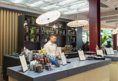 Modern reception desk and coffee bar with warm lighting and wood finishes.