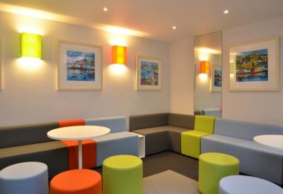 Contemporary break area with colourful modular seating and framed local photography.