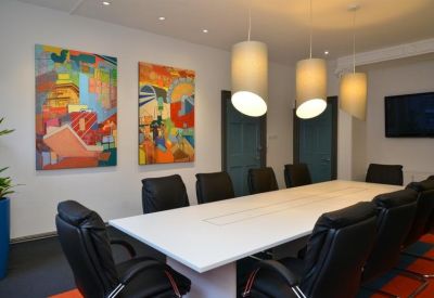 Professional boardroom with black leather chairs and modern cylinder pendant lighting.