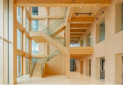 Spacious timber atrium with a grand staircase and light wood finishes.