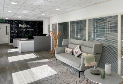 Bright reception area with a grey front desk and comfortable seating.