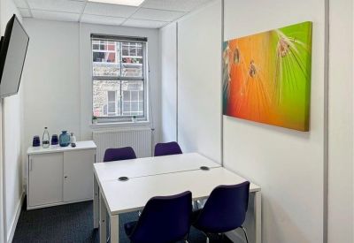 Bright private four-person office with a large nature-themed art piece.