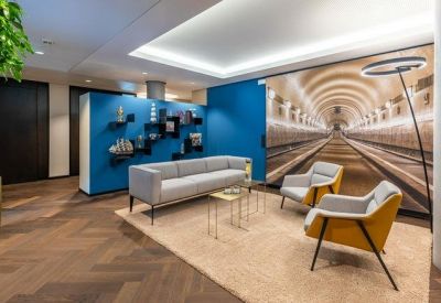 Lounge area featuring a blue feature wall, a grey sofa, and a large arched tunnel mural.
