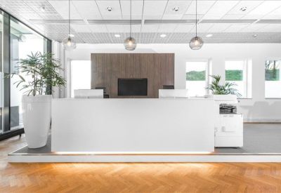 Sleek white reception desk with wood-paneled background and modern globe pendant lights.