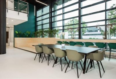 Communal dining area with long table and green accents.
