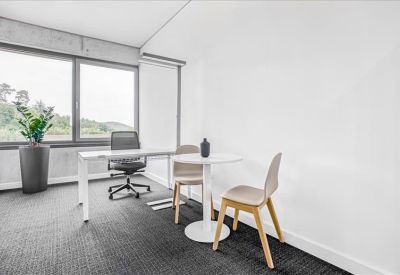 Bright private office with a white desk and two guest chairs.