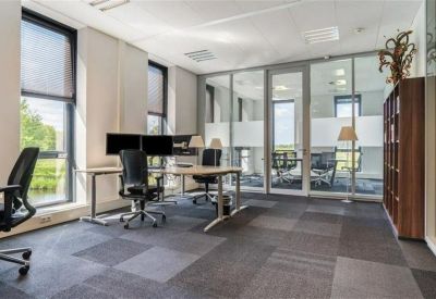 Luminous private office with two workstations and glass partition walls.