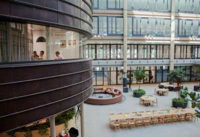 Bright lobby with a curved dark wood wall overlooking the central atrium space.