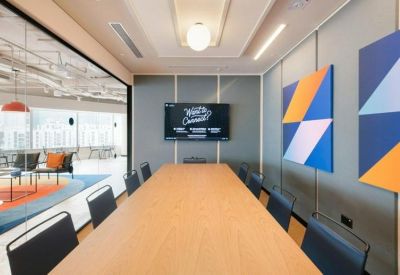 Sleek meeting room with a long wooden table and geometric blue and orange wall art.