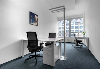Private two-person office with white desks and black mesh chairs.