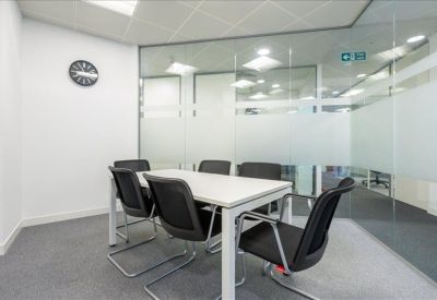 Meeting room with glass partitions and a white conference table.