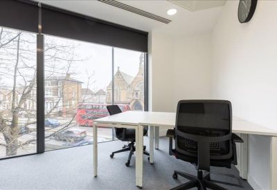 Bright workspace featuring several desk clusters and views of the surrounding area.