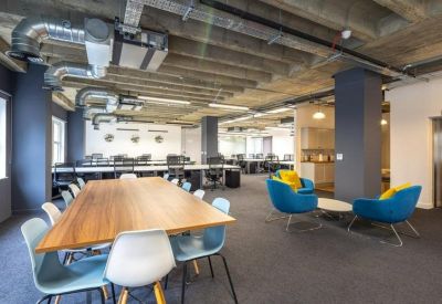 Meeting area with a long wooden table and blue task chairs.