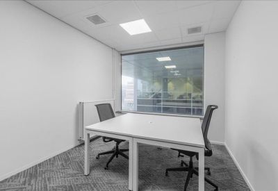 Private two-person office suite with white desks and gray carpeting.