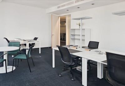 Modern white kitchen island with black bar stools and a city landscape photo.