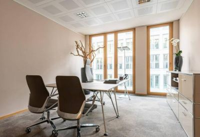 Small private office with a white desk and a views through large windows.