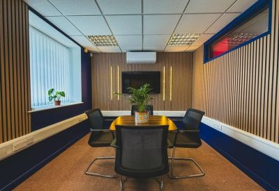 Small meeting room with wall-mounted display and four chairs