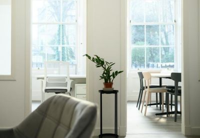 View through a doorway showing a bright office space and meeting area.