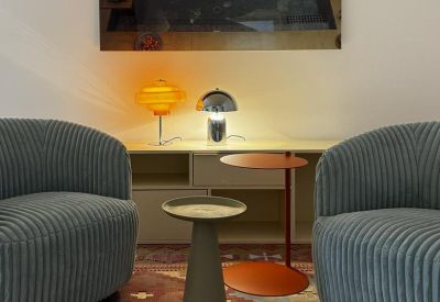 Waiting area with blue corduroy armchairs and a patterned rug at 10, Cecilienallee, Cecilienpalais.