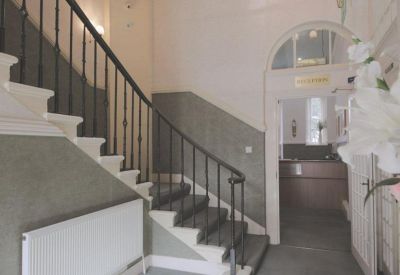 Traditional grand staircase and reception area with stone steps and an arched doorway.