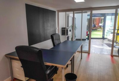 Compact office with two chairs facing glass partitions.