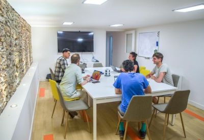 Meeting room with a large table and a wall-mounted TV.