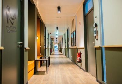 Bright office corridor with light wood floors and minimalist doors.