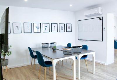 Modern meeting room with blue chairs and a large whiteboard.