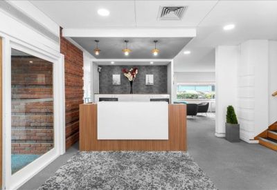 Professional reception desk with wood accents and warm pendant lighting.