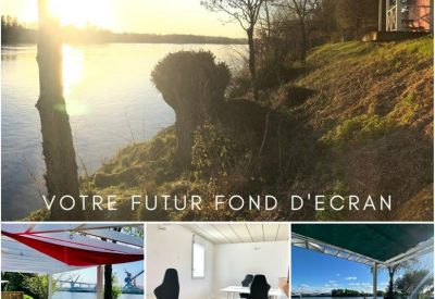 Riverside outdoor terrace with a wooden deck and picnic table by the water.