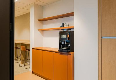 Glass-walled room with a person walking past, showcasing a private office area.