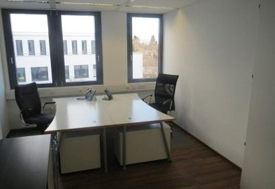 Small private office with two workstations and large windows.