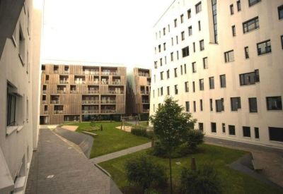 Shared grassy courtyard surrounded by modern white and wood-clad buildings.