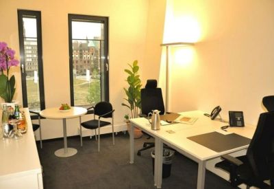 Private office featuring two desks, a meeting table, and views of the city.