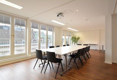 Bright private office featuring two desks and white storage cabinets.