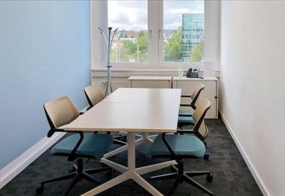 Bright lounge area with hardwood floors, contemporary furniture, and a spiral staircase.