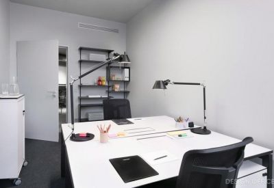 Minimalist private office with a white double desk and two task lamps.